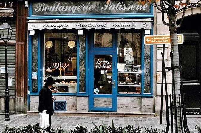 A blue boulangerie-pâtisserie front in the Jewish quarter, a menorah in the window