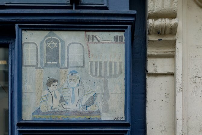 An old painted sign framed on a shopfront, a menorah and two figures at a table