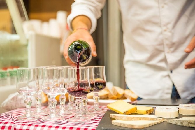 Red wine poured into tasting glasses over a board of French cheese